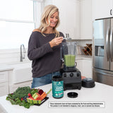 woman scooping. Organic SuperGreens Powder Watermelon into a blender