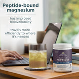 Supplement container labeled 'Active Peptides Magnesium' on a desk with a glass of juice and blurred background.