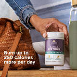Person holding a container of 'Active Peptides' supplement with text about calorie burn on a wooden surface.