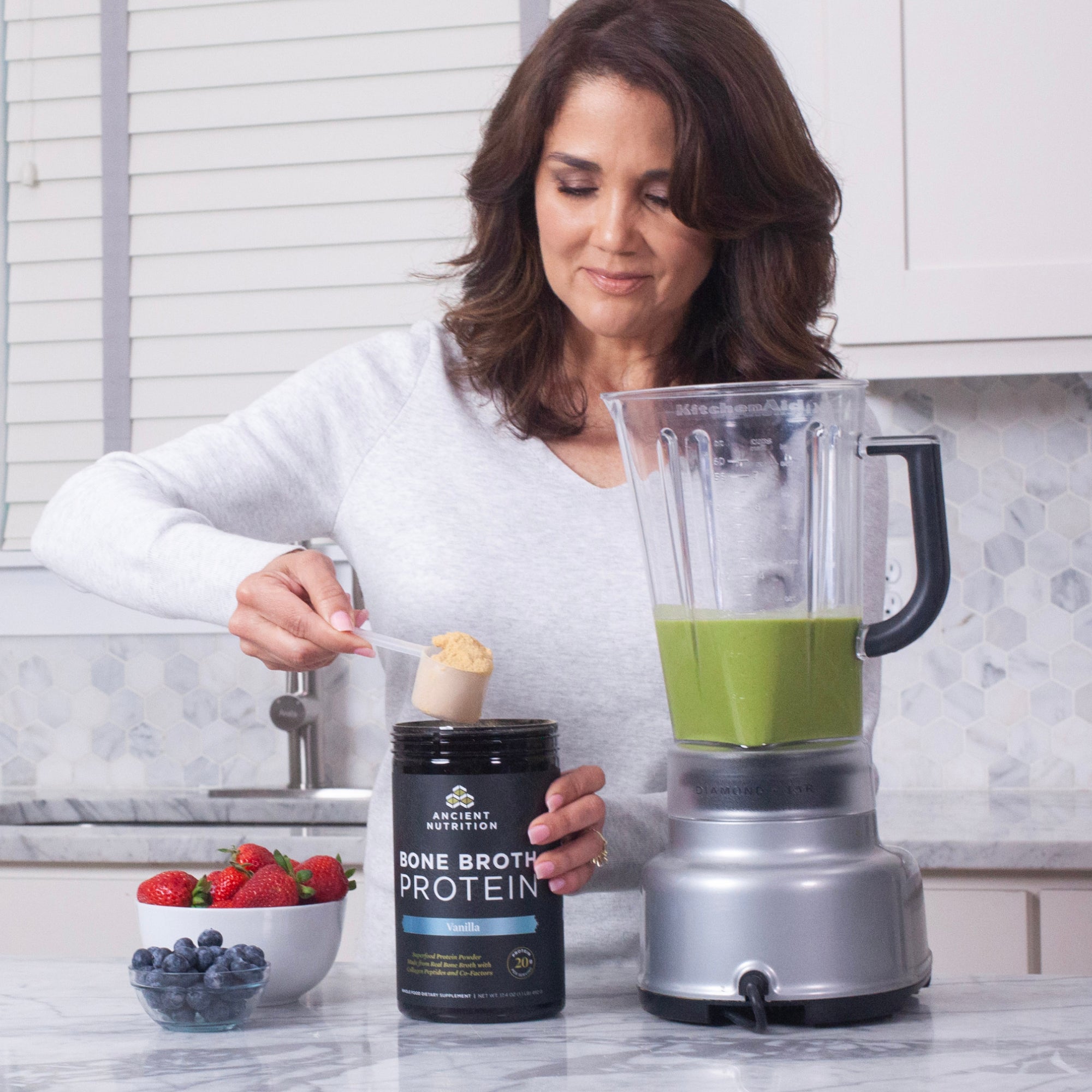 woman making a smoothie with bone broth protein vanilla