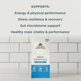 Ancient Nutrition Men's Essentials Variety Pack box standing on a white surface against a white subway tile wall, with dark teal text above listing benefits such as energy, stress resilience, gut microbiome support, and healthy male vitality.