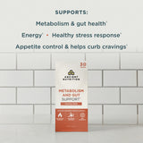 A box of Ancient Nutrition Metabolism and Gut Support +Variety Pack stands on a white surface against a white subway tile wall. Above the product, text reads: 'SUPPORTS: Metabolism & gut health, Energy, Healthy stress response, Appetite control & helps curb cravings.