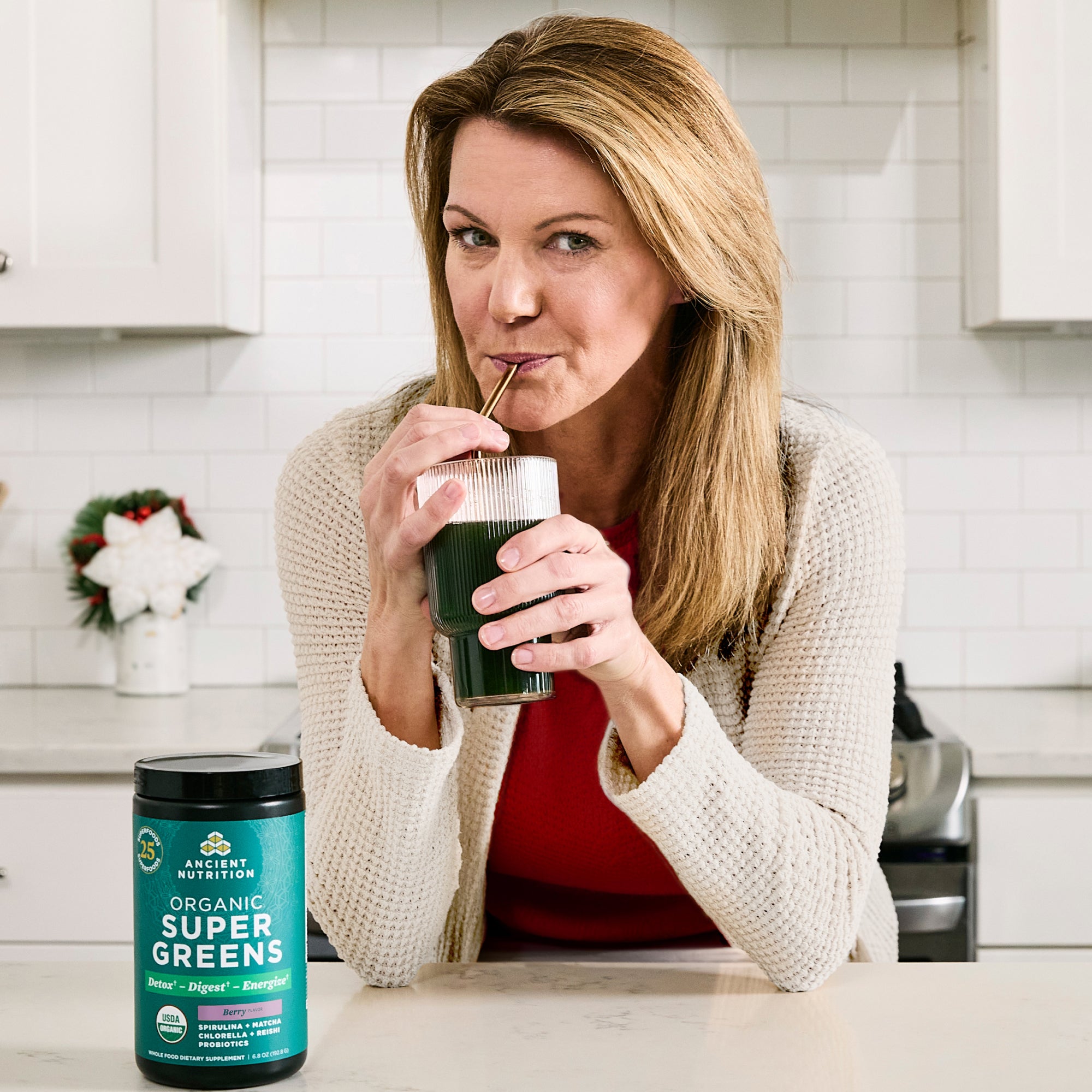 a woman drinking organic supergreens berry