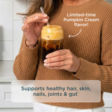 A woman in a brown ribbed sweater holds a frothy iced coffee with a clear straw. Text on the image says 'Limited-time Pumpkin Cream flavor!' and 'Supports healthy hair, skin, nails, joints & gut'.