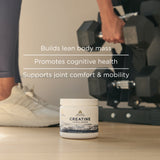 Container of Creatine + Collagen supplement with person lifting weights in the background