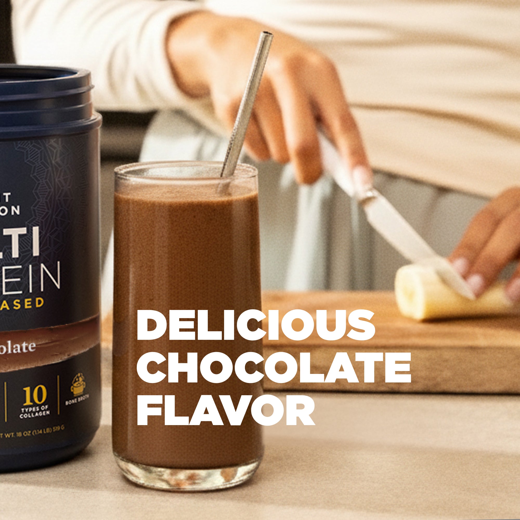 Glass of chocolate protein shake with a container of protein powder and a banana on a wooden cutting board.