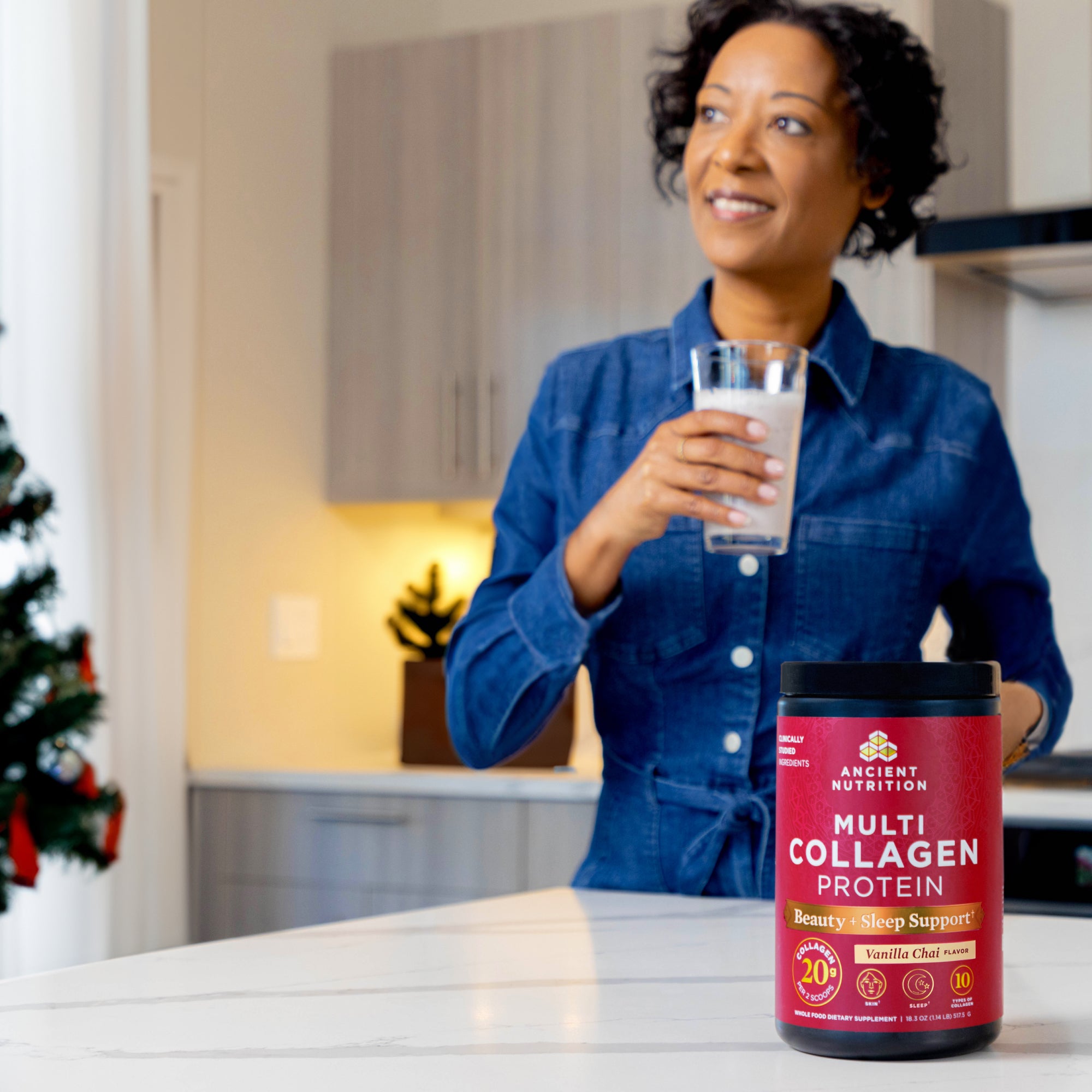 a woman in a kitchen drinking multi collagen protein