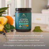 Ancient Nutrition Organic Super Greens Bloat Relief supplement jar on a kitchen counter with fruits and greens.