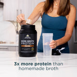 a woman getting a scoop of Bone Broth Protein Powder Chocolate (40 Servings) 