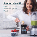 Woman preparing a smoothie with Ancient Foods Bone Broth Protein in a kitchen.