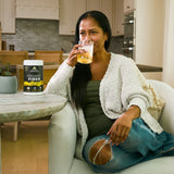 a woman drinking a glass of Organic Fiber Powder Pineapple Mango Flavor (60 Servings)