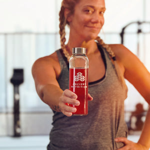 a woman holding a bottle of water with Clean Energy Powder Cherry Limeade Flavor (30 Servings) mixed in