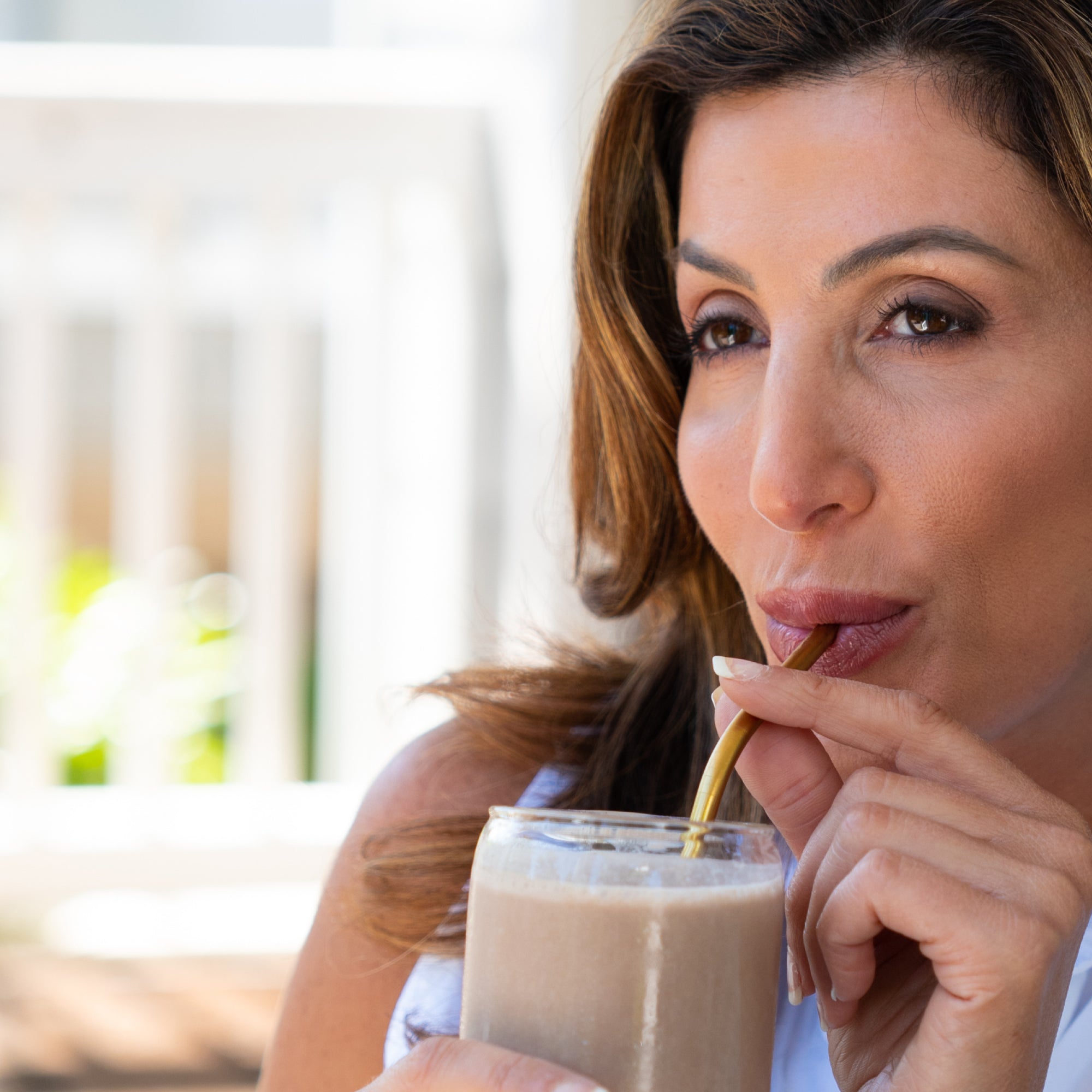 a woman drinking a smoothie