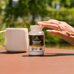 a bottle of Regenerative Organic Certified® Menopause Support Probiotics Capsules (60 Capsules) next to a coffee cup