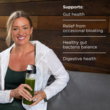 Woman holding a green smoothie with text about health benefits on a wooden background