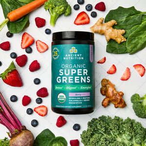 Organic SuperGreens Powder Berry Flavor (25 Servings) surrounded by fruits and vegetables