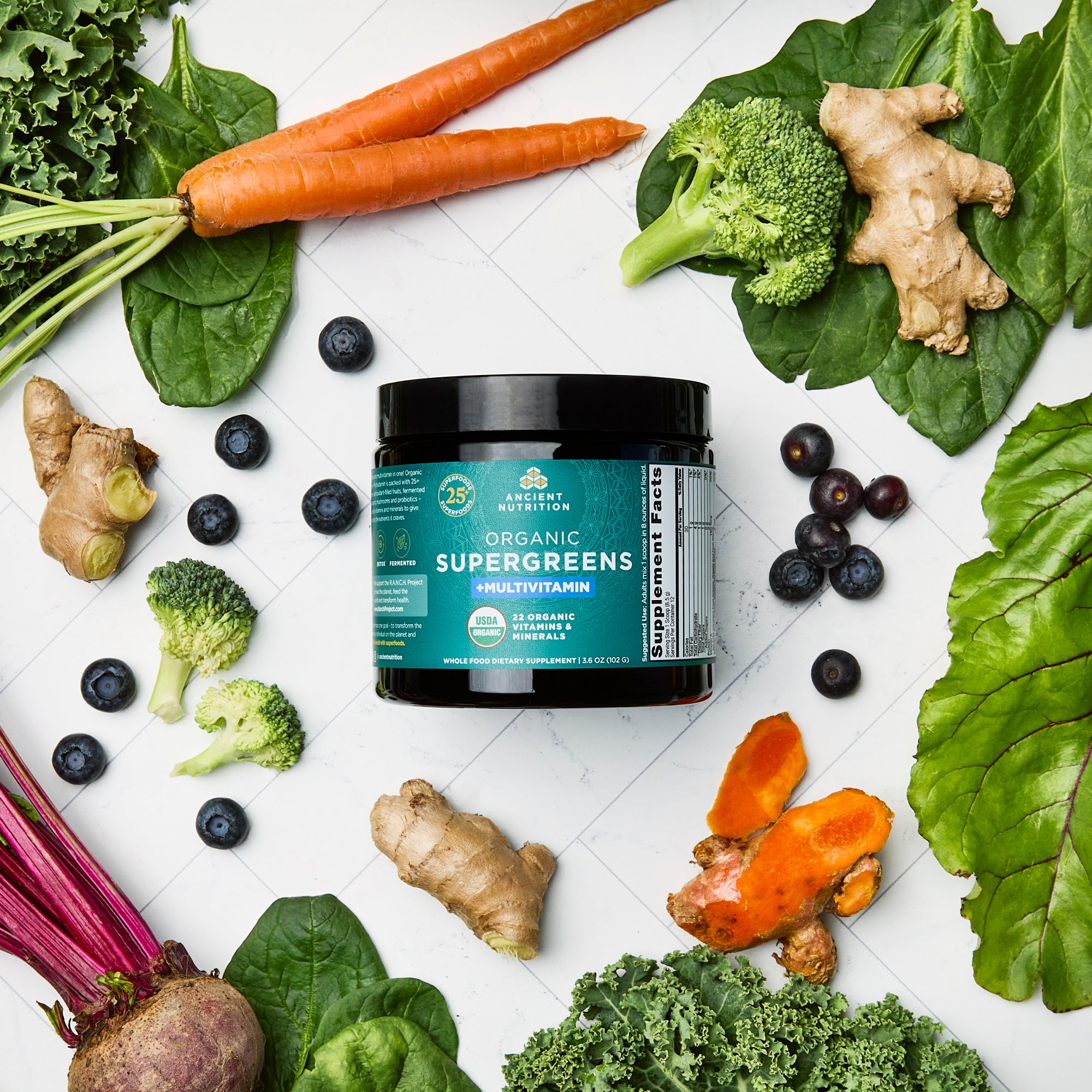 Organic SuperGreens + Multivitamin Powder (12 Servings) surrounded by fruits