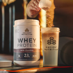 a bottle of Whey Protein Powder Chocolate next to a shaker bottle