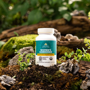 bottle of Regenerative Organic Certified™ Women's Hormones on a mossy rock