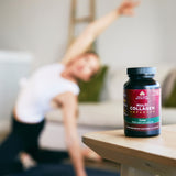 Multi Collagen Advanced Lean Capsules on a table with a woman doing yoga in the background