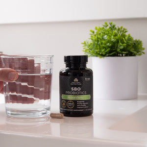 SBO probiotics mental clarity next to a glass of water