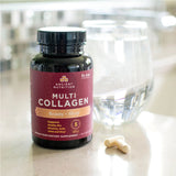 multi collagen capsules beauty sleep bottle next to a glass of water