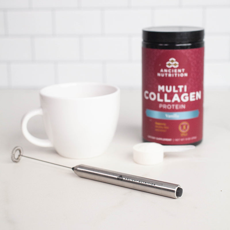 hand held frother next to a white mug and bottle of multi collagen protein vanilla