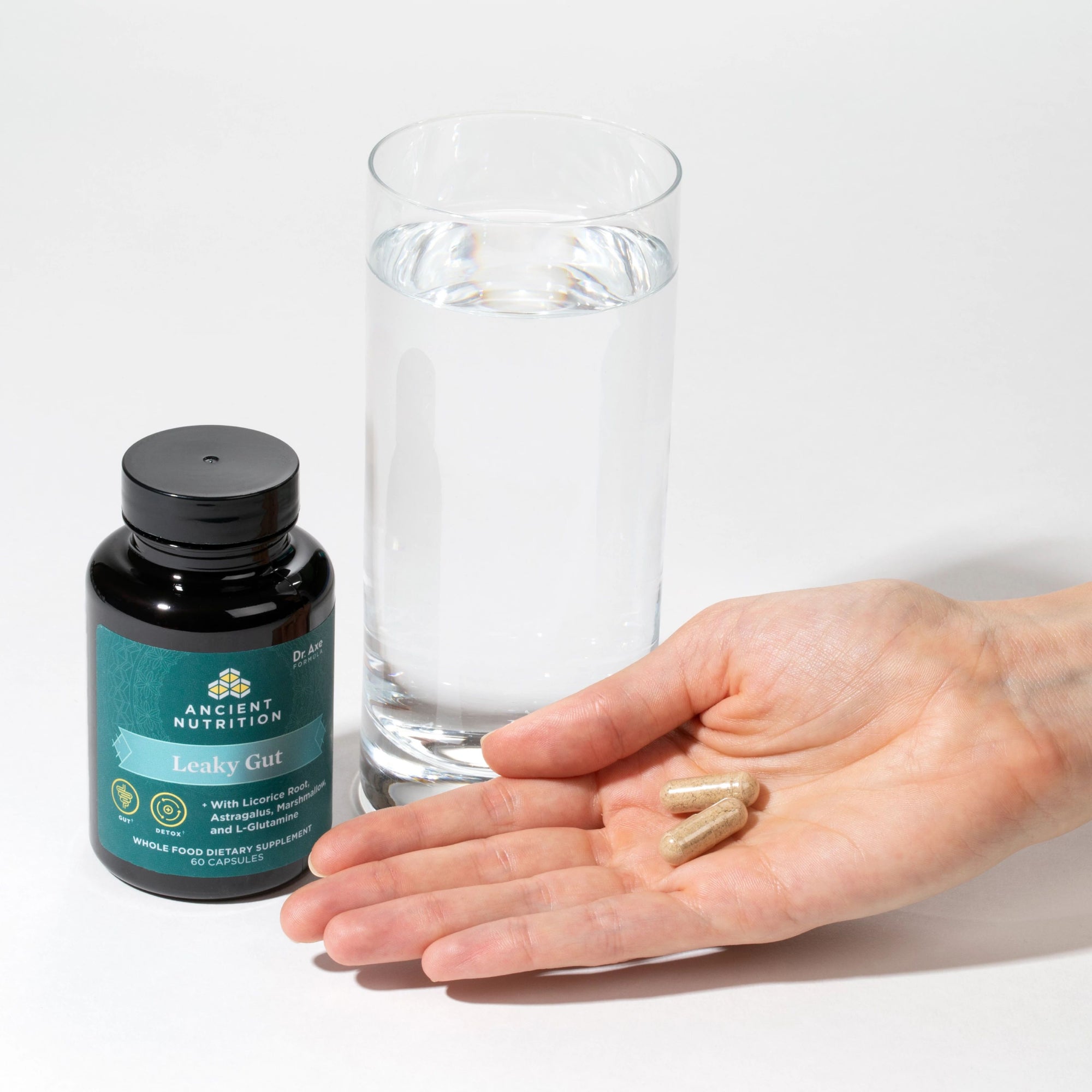person holding leaky gut capsules in hand