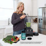 woman making a green smoothie