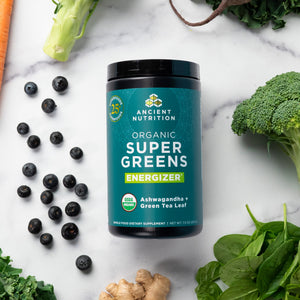 Organic Super Greens Energize Powder surrounded by fruits and veggies