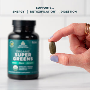 person holding a Organic SuperGreens Tablet